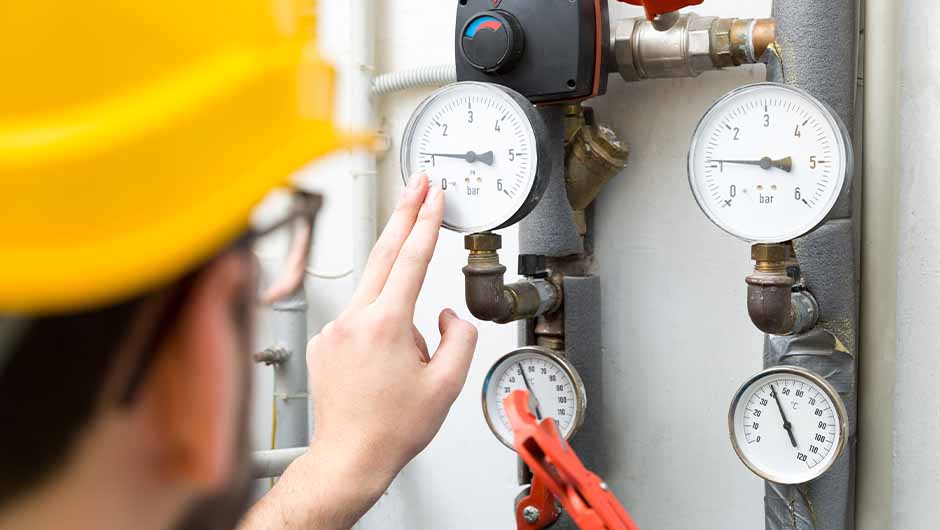 Technician checking pressure meters Technician checking pressure meters