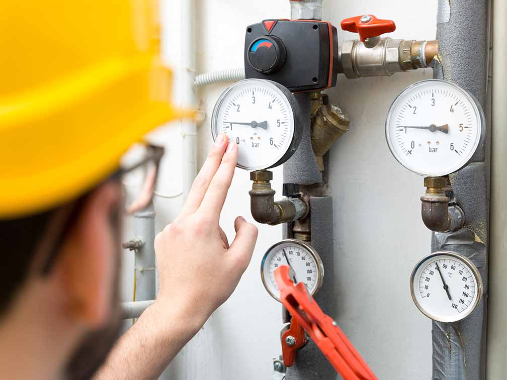 Technician checking pressure meters Technician checking pressure meters